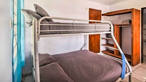 A bunk bed with a lower bunk and a single bed, a wooden wardrobe, and a blue curtain. - Tropical Oasis: Bay Views ~ 2 Mi to Playa Sardinas (Culebra)