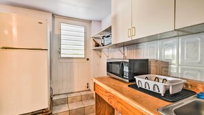 A compact kitchen with white cabinets, a microwave, a sink, and a wooden countertop. - Tropical Oasis: Bay Views ~ 2 Mi to Playa Sardinas (Culebra)