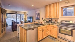 A kitchen with wooden cabinets, a granite countertop, a dishwasher, and a stainless steel oven. - Ski-in/ski-out Condo w/ Hot Tub on Copper Mountain (Copper Mountain)