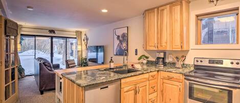 A kitchen with wooden cabinets, a granite countertop, a dishwasher, and a stainless steel oven.