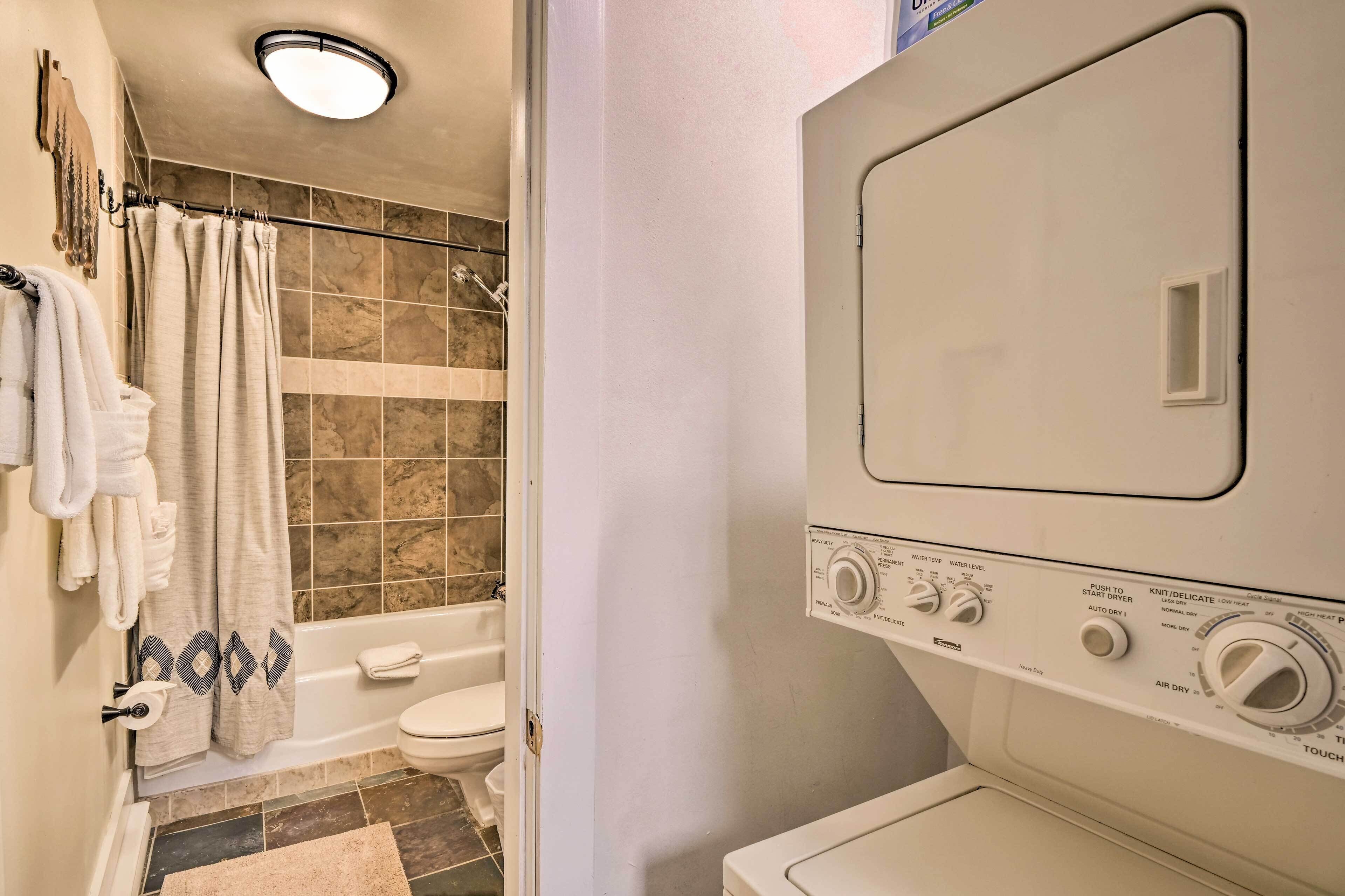 A bathroom with a bathtub, toilet, and a washing machine.