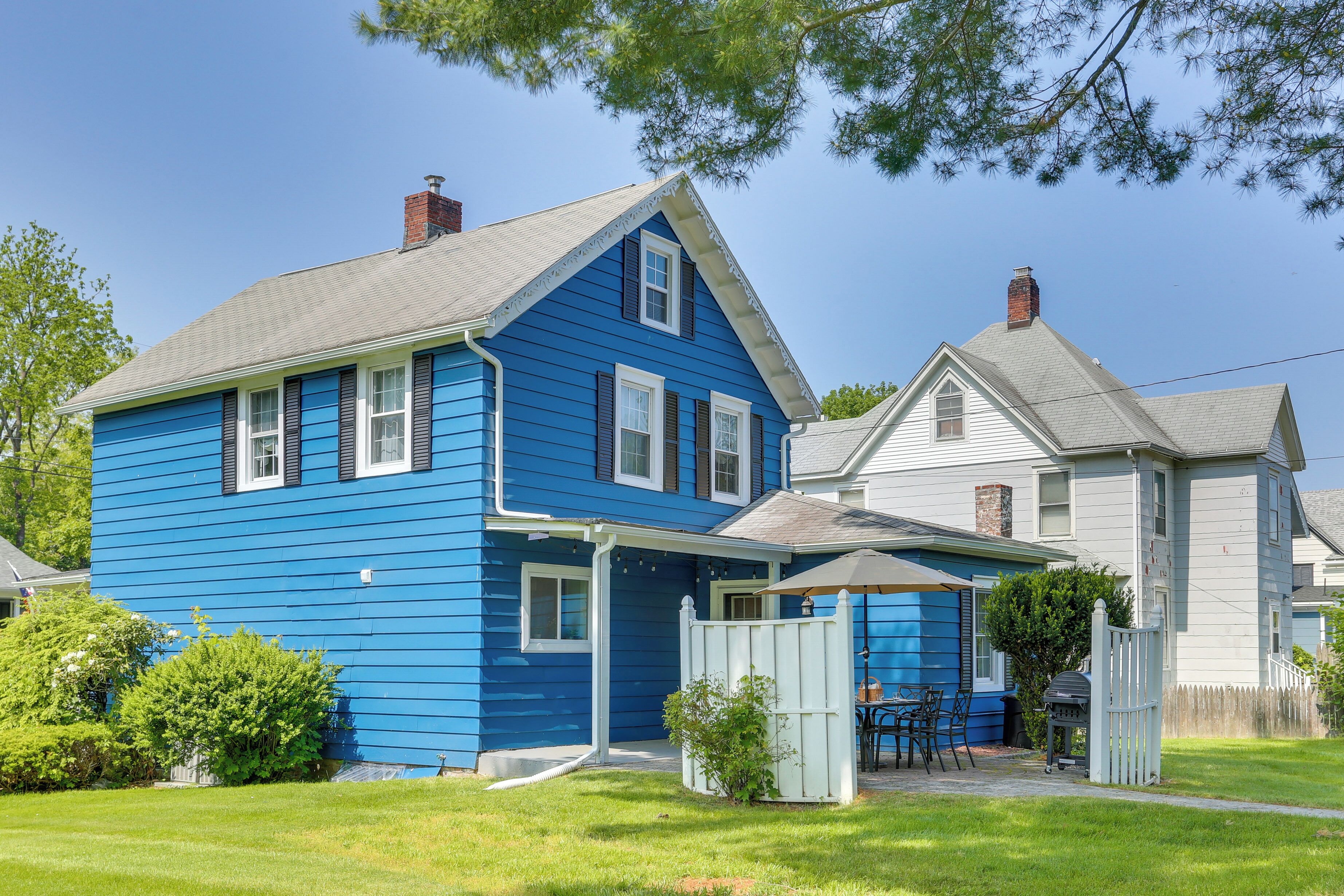 A two-story house with a blue exterior and a grey roof.