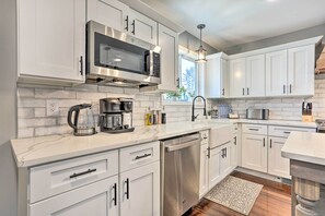 A modern kitchen with white cabinetry, stainless steel appliances, and a marble countertop. - Bright Cornwall-on-hudson Vacation Rental! (Cornwall)