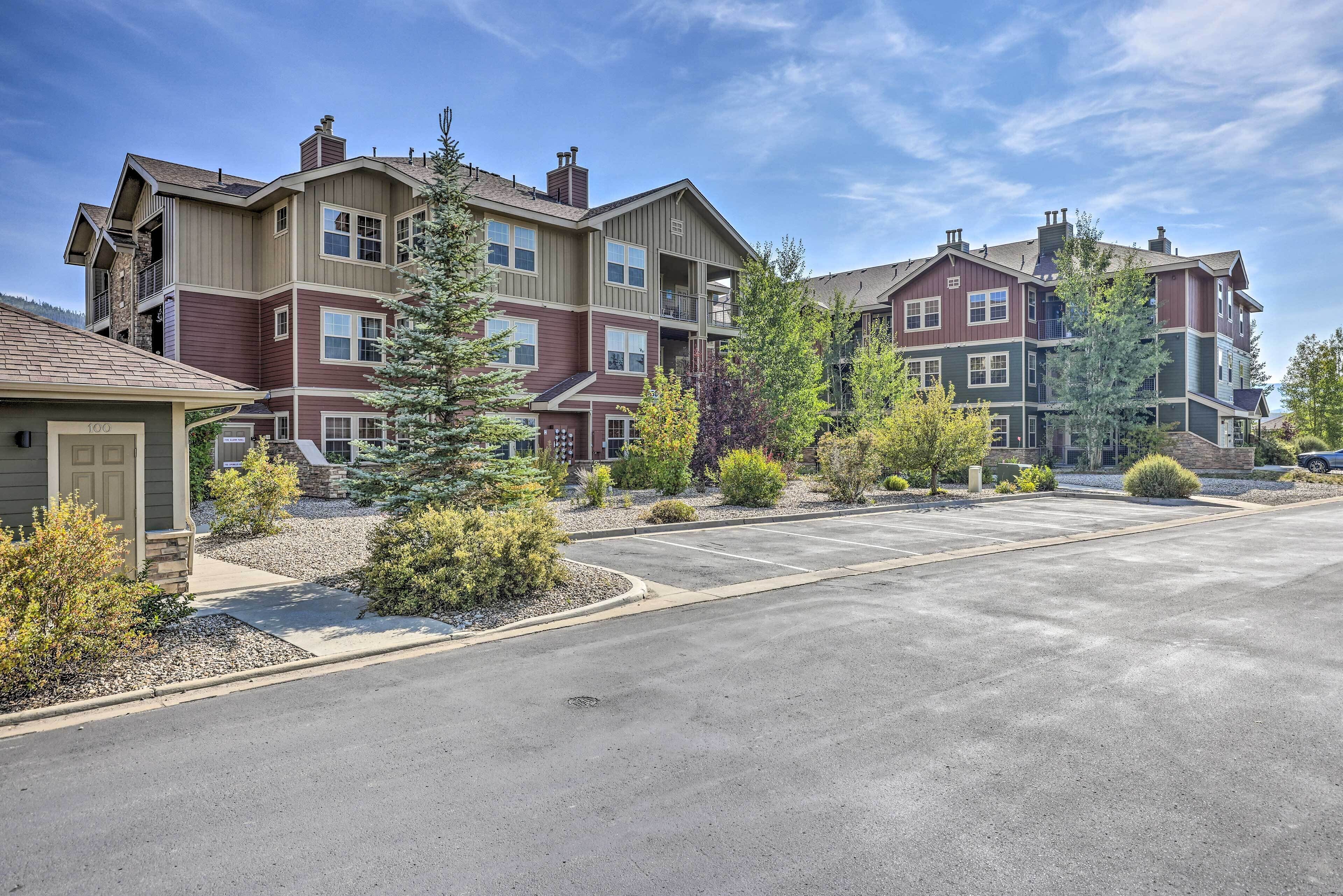 A multi-story residential building with a parking lot and landscaped areas.