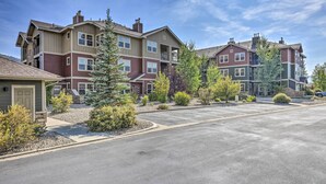 A multi-story residential building with a parking lot and landscaped areas. - Ski, Hike & Golf: Granby Condo w/ Shared Amenities (Granby)