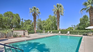 A rectangular swimming pool with clear blue water, surrounded by palm trees and lounge chairs. - Beautiful Gated Country Club, Prime Location (Palm Desert)