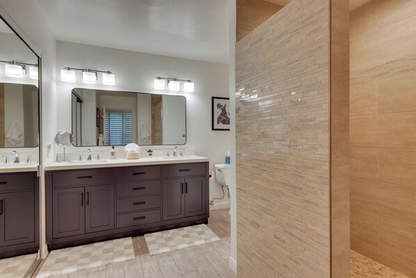 A bathroom with a double vanity, two sinks, a large mirror, and a shower area. - Beautiful Gated Country Club, Prime Location (Palm Desert)