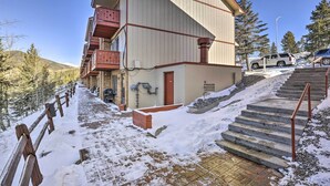 A multi-story building with a red balcony, a staircase leading to the entrance, and a snow-covered ground. - 7 Mi to Keystone: Mtn-view Abode w/ Deck! (Dillon)