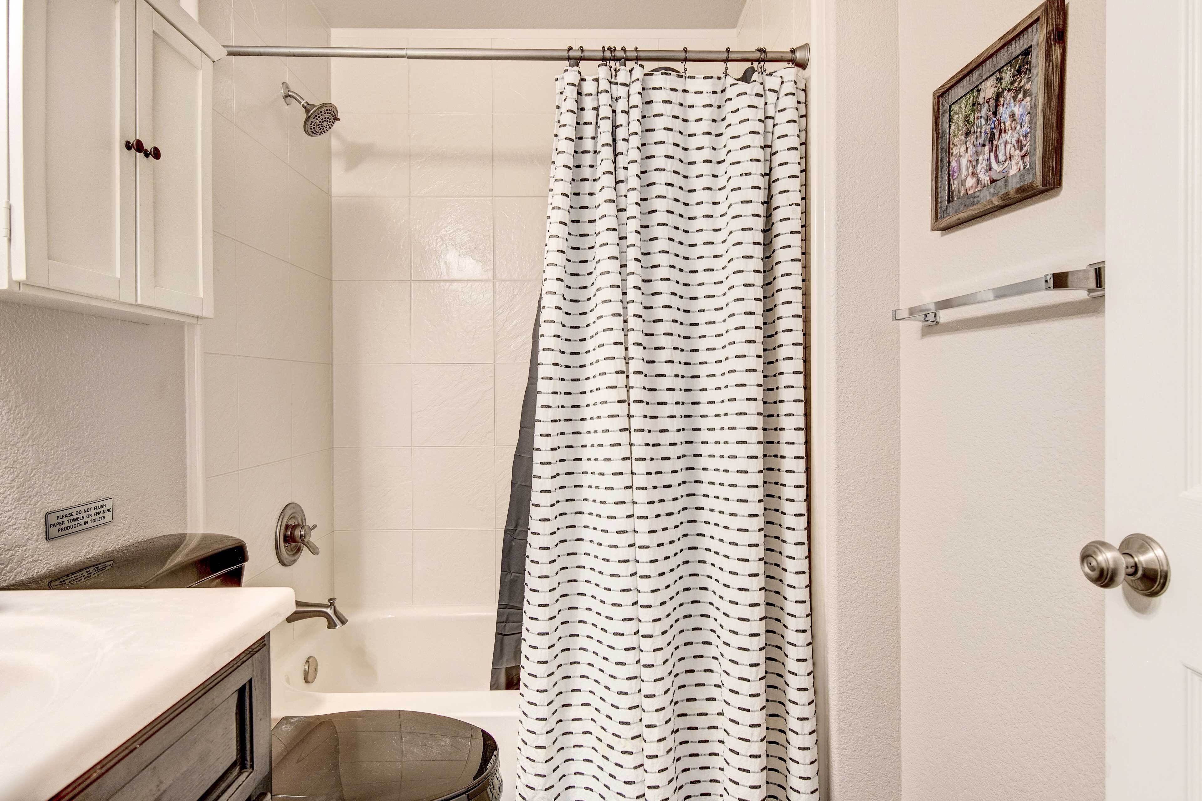 A bathroom with a shower, toilet, and sink.