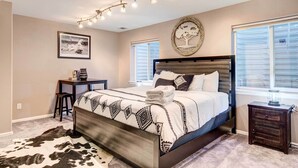 A bedroom with a bed, a desk, a chair, a rug, and a nightstand. - Denver Townhome in Highlands w/ Spacious Yard! (Denver)