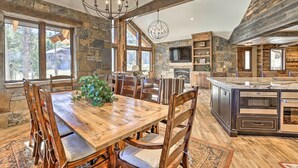 Una cocina rústica con una gran mesa de madera, paredes de piedra y una chimenea de piedra.