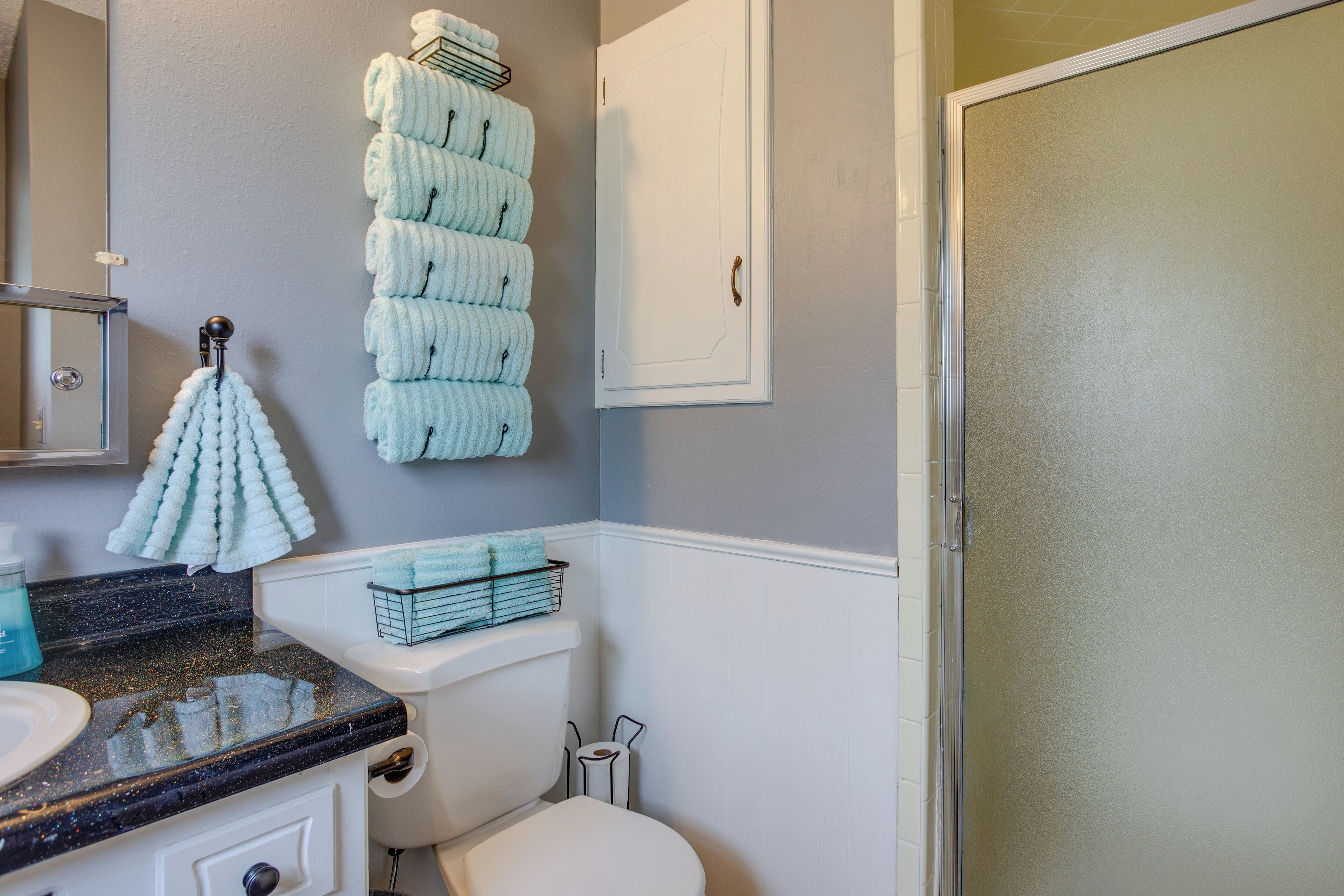 A bathroom with a toilet, sink, and towel rack.