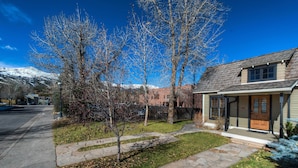 A residential house with a stone pathway leading to the front door, surrounded by a small lawn and leaf-covered ground. - Downtown Breckenridge Cottage: Walk to Main St! (Breckenridge)