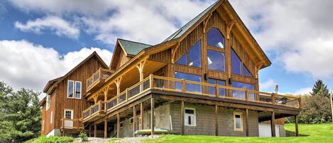 A large wooden house with multiple balconies and large windows.