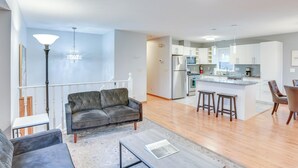 A modern apartment with a living room, kitchen, and dining area.