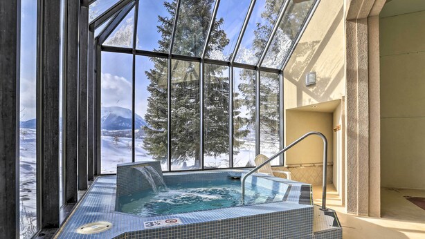 A glass-enclosed hot tub with a view of snow-covered mountains and trees. - Mtn Views, Ground Floor: Rec Path and Lake Access (Dillon)