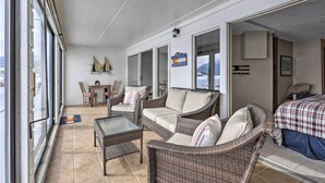 A spacious balcony with wicker furniture, a dining area, and a bed with a plaid bedspread. - Mtn Views, Ground Floor: Rec Path and Lake Access (Dillon)
