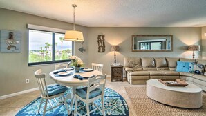 A living room with a dining area, a sofa, and a coffee table.