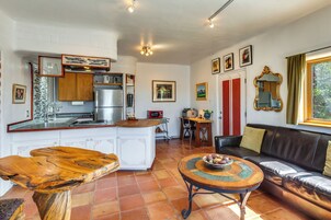 Una cocina moderna con armarios blancos, un refrigerador de acero inoxidable y una mesa de comedor de madera.