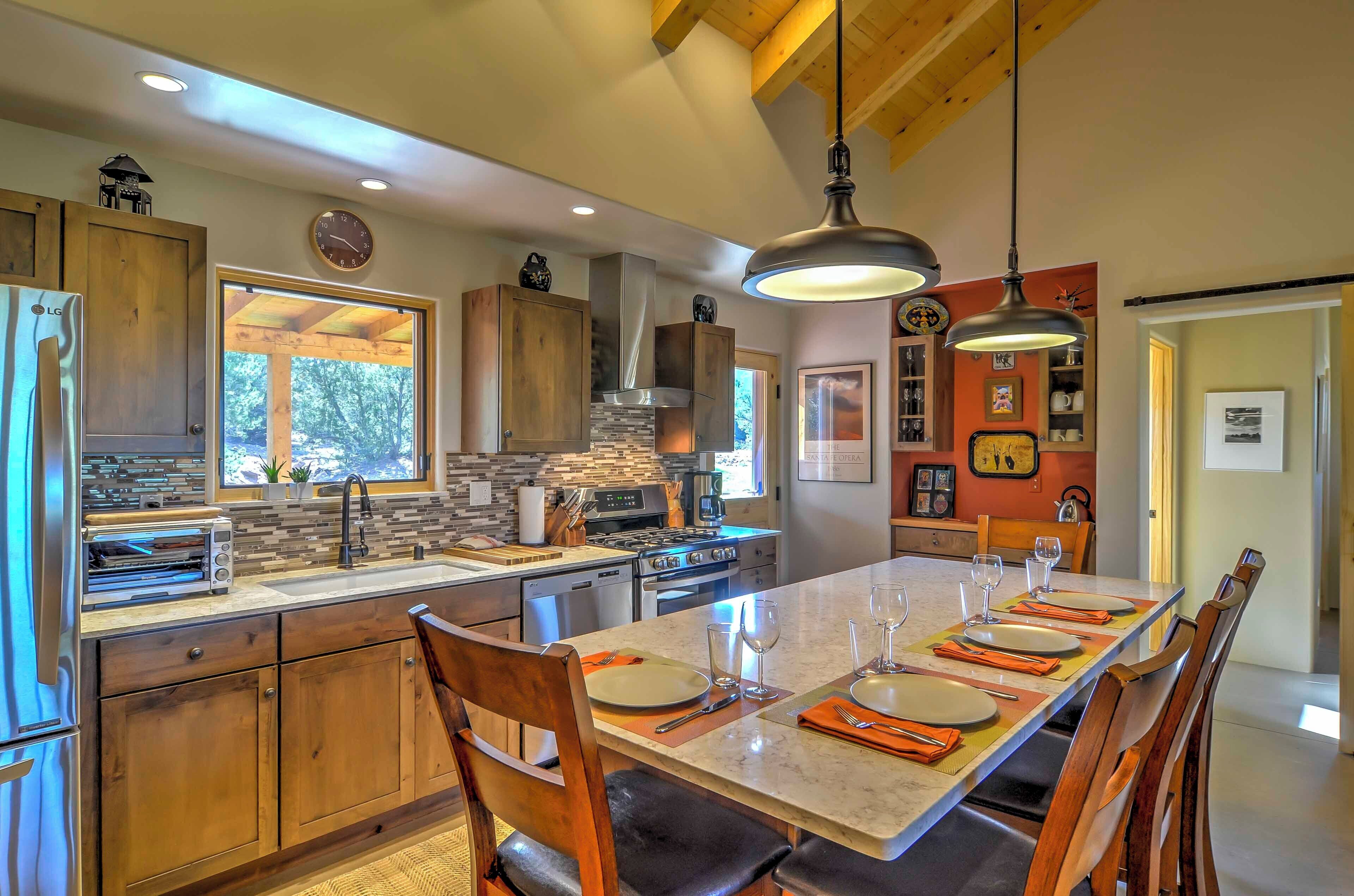 A modern kitchen with wooden cabinets, a large island, and a dining area set for six.