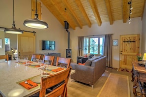 A dining area with a marble table set for four, wooden chairs, and pendant lights. - Hidden Santa Fe Gem - Nestled in Tesuque Hills! (Santa Fe)