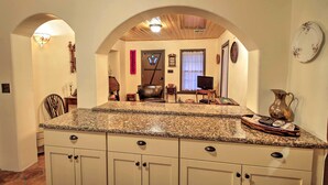 A kitchen with granite countertops, white cabinets, and a wooden ceiling. - Charming Couples Casita, Walk to Old Mesilla Plaza (Mesilla)