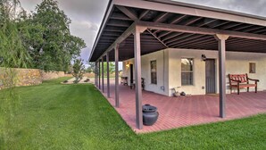 A covered patio area with a stone wall, a bench, and a potted plant. - Charming Couples Casita, Walk to Old Mesilla Plaza (Mesilla)