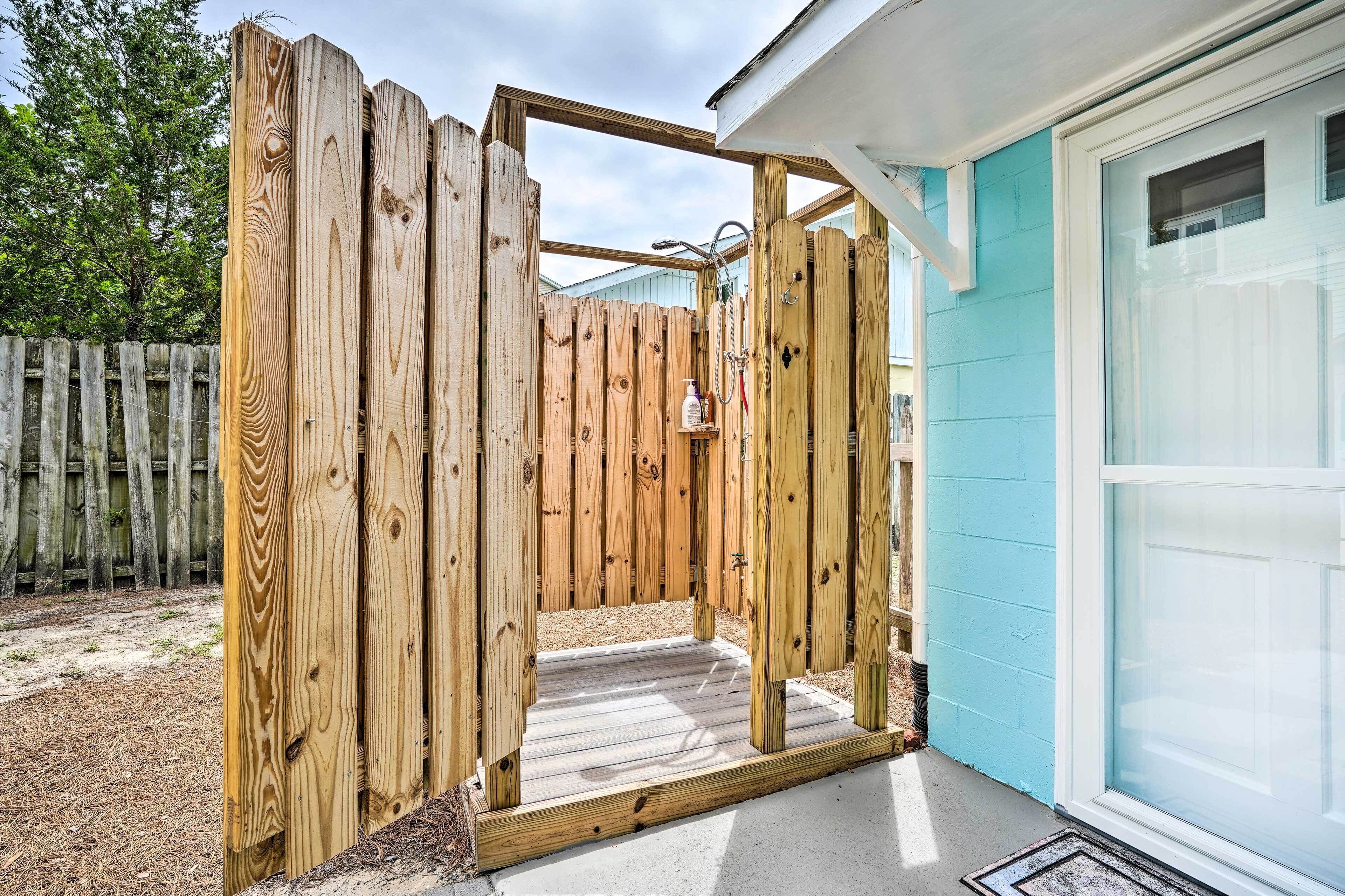 A wooden structure with a metal door, a small shelf, and a hose.
