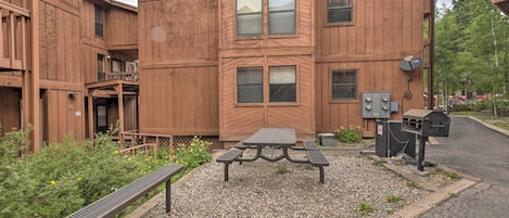 A wooden building with a picnic table and benches in front.