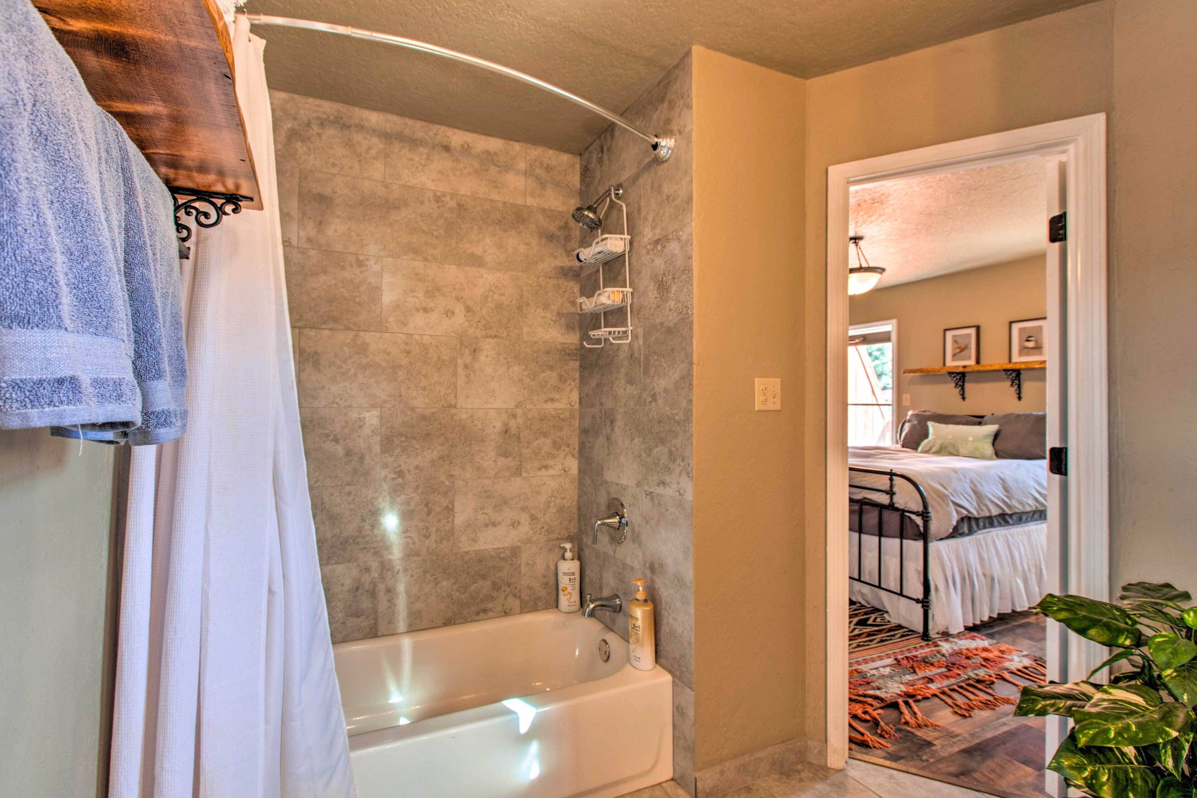 Une salle de bain avec une baignoire, une douche et un porte-serviettes.