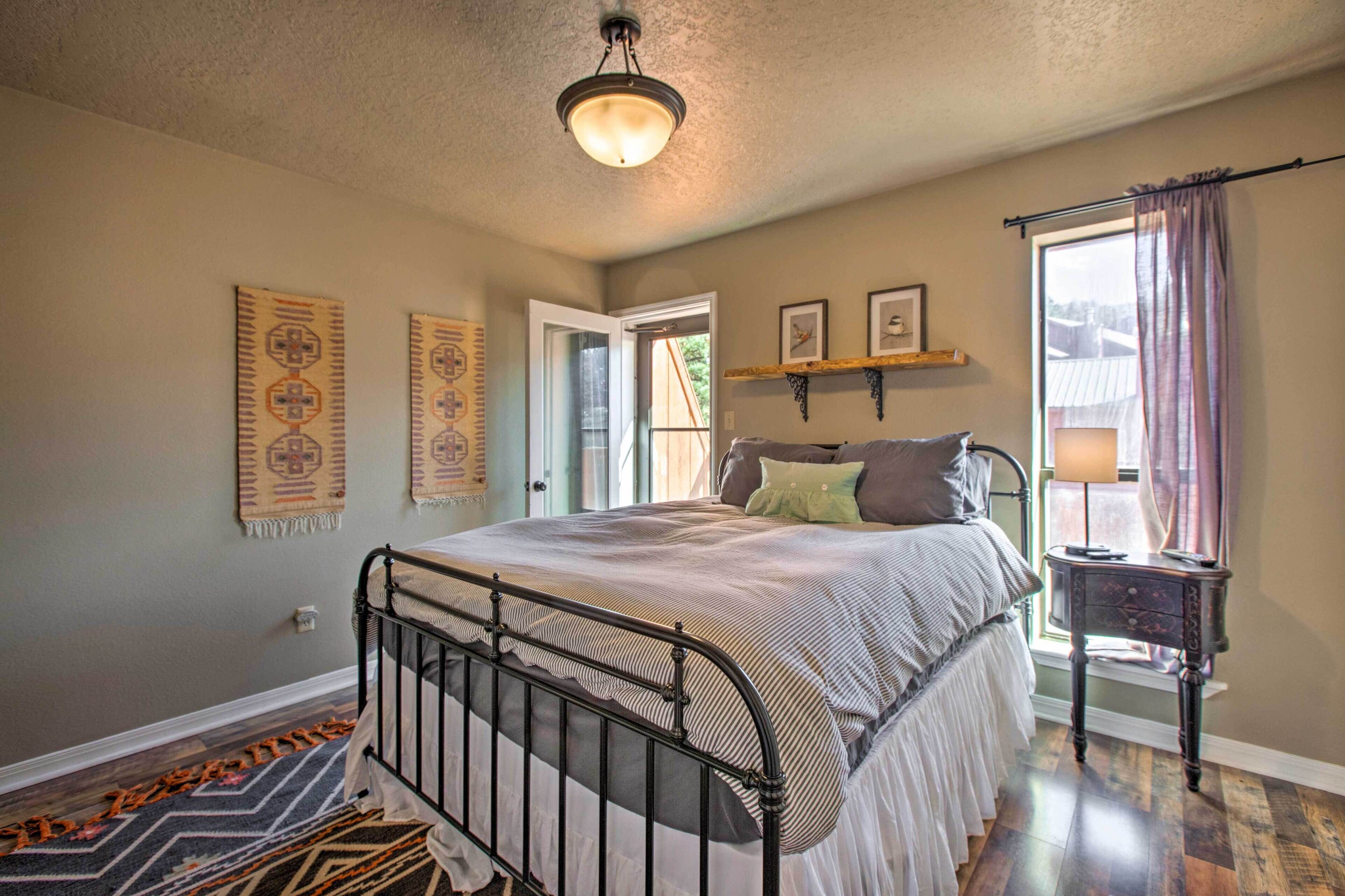 Une chambre à coucher comprenant un lit, une table de chevet, une lampe, une fenêtre avec des rideaux et des éléments de décoration murale.