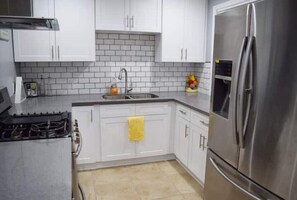 Enjoy cooking in this well-equipped kitchen with a gas stove, refrigerator, and ample countertop space.