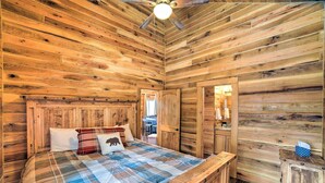 A wooden cabin bedroom with a bed, a ceiling fan, and a wooden wardrobe. - Woodsy Mountain Cabin: 2 Mi to Angel Fire Resort! (Angel Fire)