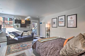 A modern living room with a sofa, a bed, and a small kitchen area. - Telluride Studio in Downtown - Walk to Gondola! (Telluride)