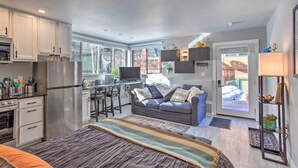A compact kitchen with modern appliances, a dining area with a TV, and a cozy seating area with a sofa and cushions. - Telluride Studio in Downtown - Walk to Gondola! (Telluride)