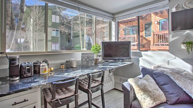 A kitchen with a large window, a coffee maker, a toaster, and a TV. - Telluride Studio in Downtown - Walk to Gondola! (Telluride)