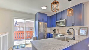 A modern kitchen with blue cabinets, a stainless steel refrigerator, a microwave, and a granite countertop. - Frisco Mountain Hub: Walk to Main Street (Frisco)