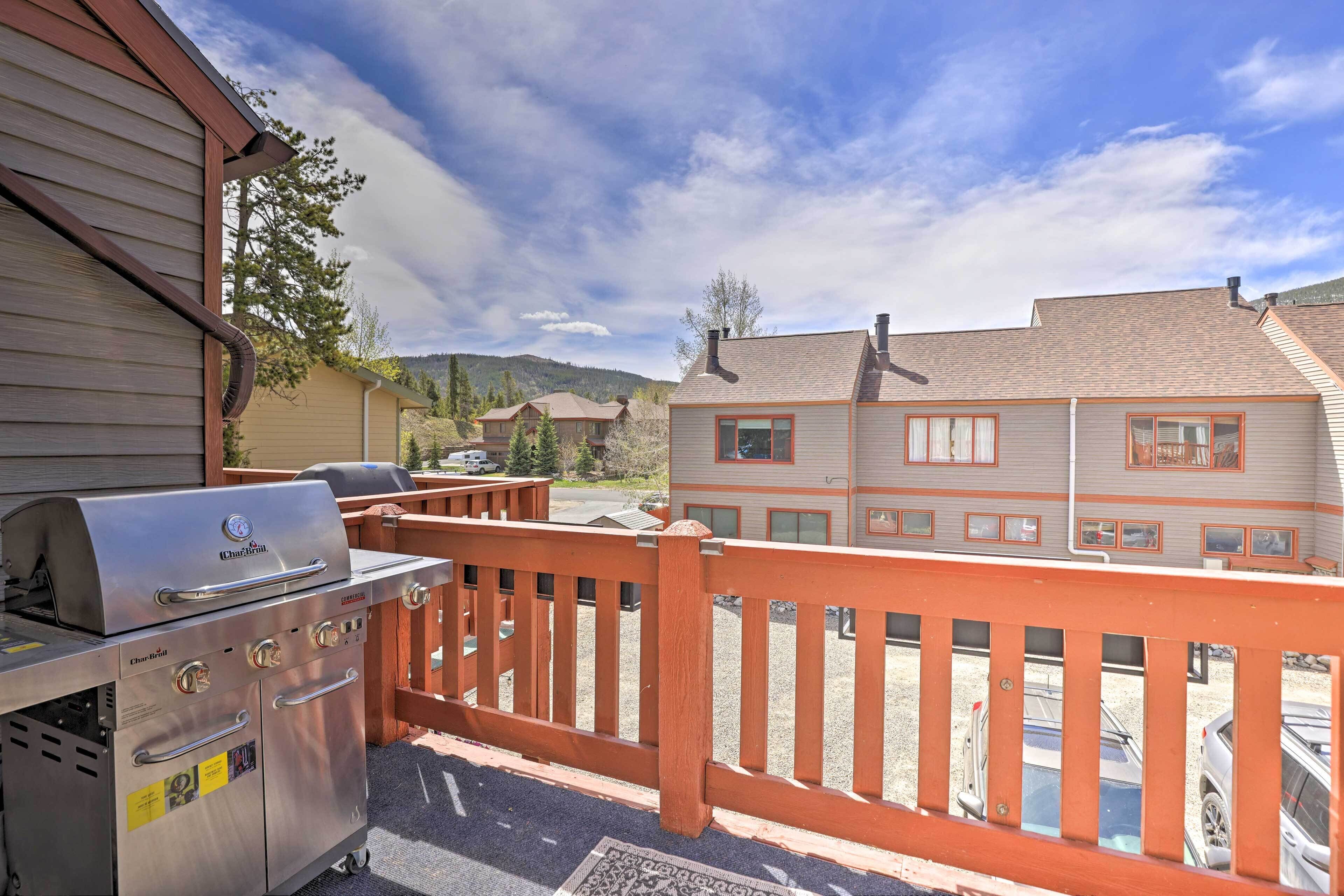 Un barbecue et une clôture en bois dans un quartier résidentiel, avec des maisons en arrière-plan.