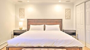 A neatly arranged bedroom with a large bed, two bedside tables, and a wooden headboard. - Frisco Mountain Hub: Walk to Main Street (Frisco)
