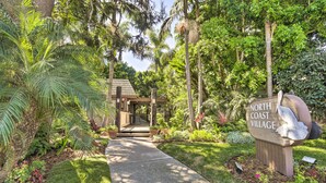 A pathway leading to a building with a sign reading "North Coast Village." - Charming Oceanside Condo w/ Beach & Pool Access! (Oceanside)