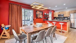 Eine moderne Küche mit Holzschränken, einem Edelstahlkühlschrank und einer Bar.