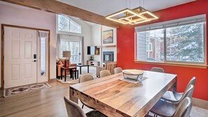 Ein modernes Interieur mit einem Holztisch, roten Wänden und großen Fenstern.