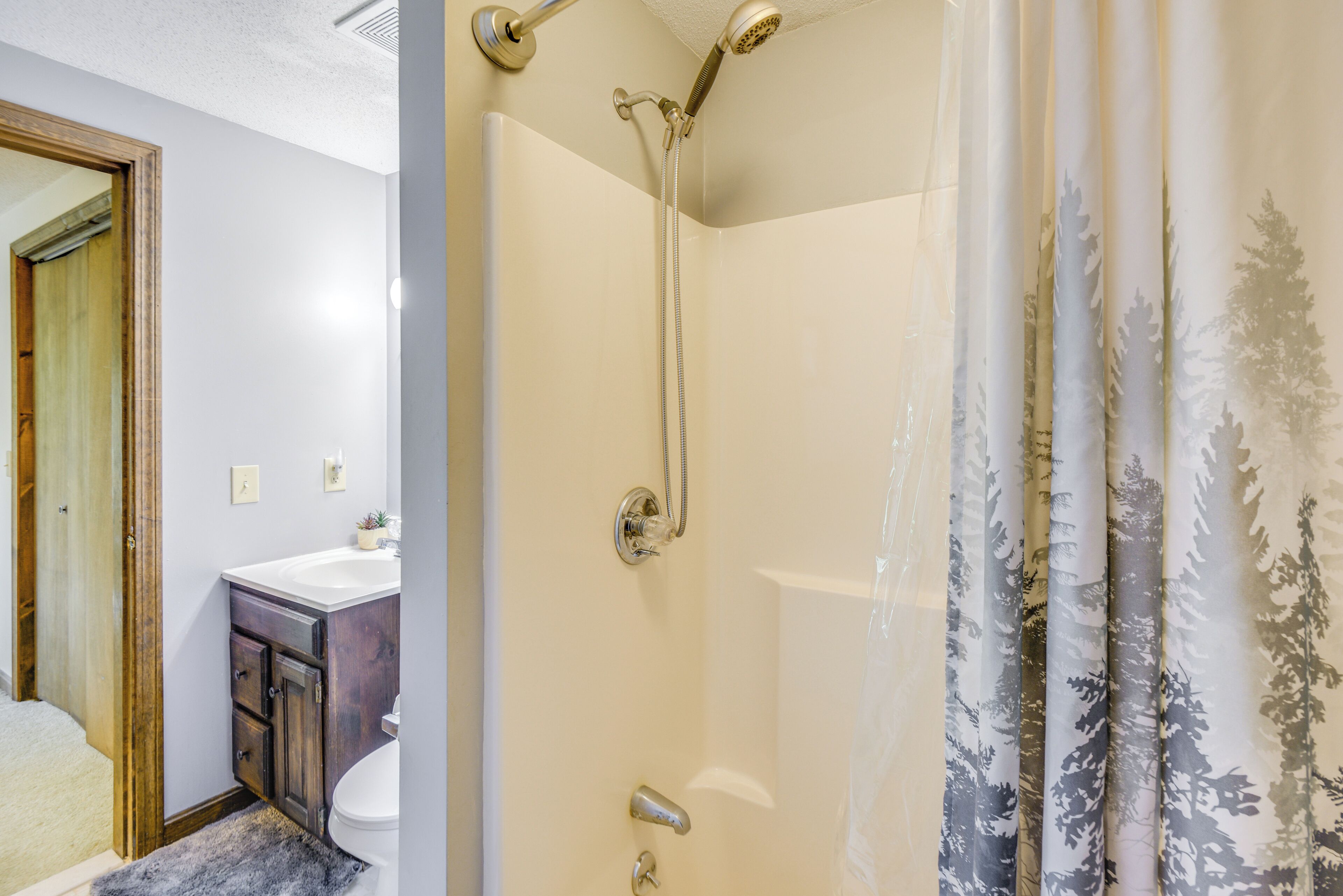 Un baño con ducha, inodoro y lavabo.