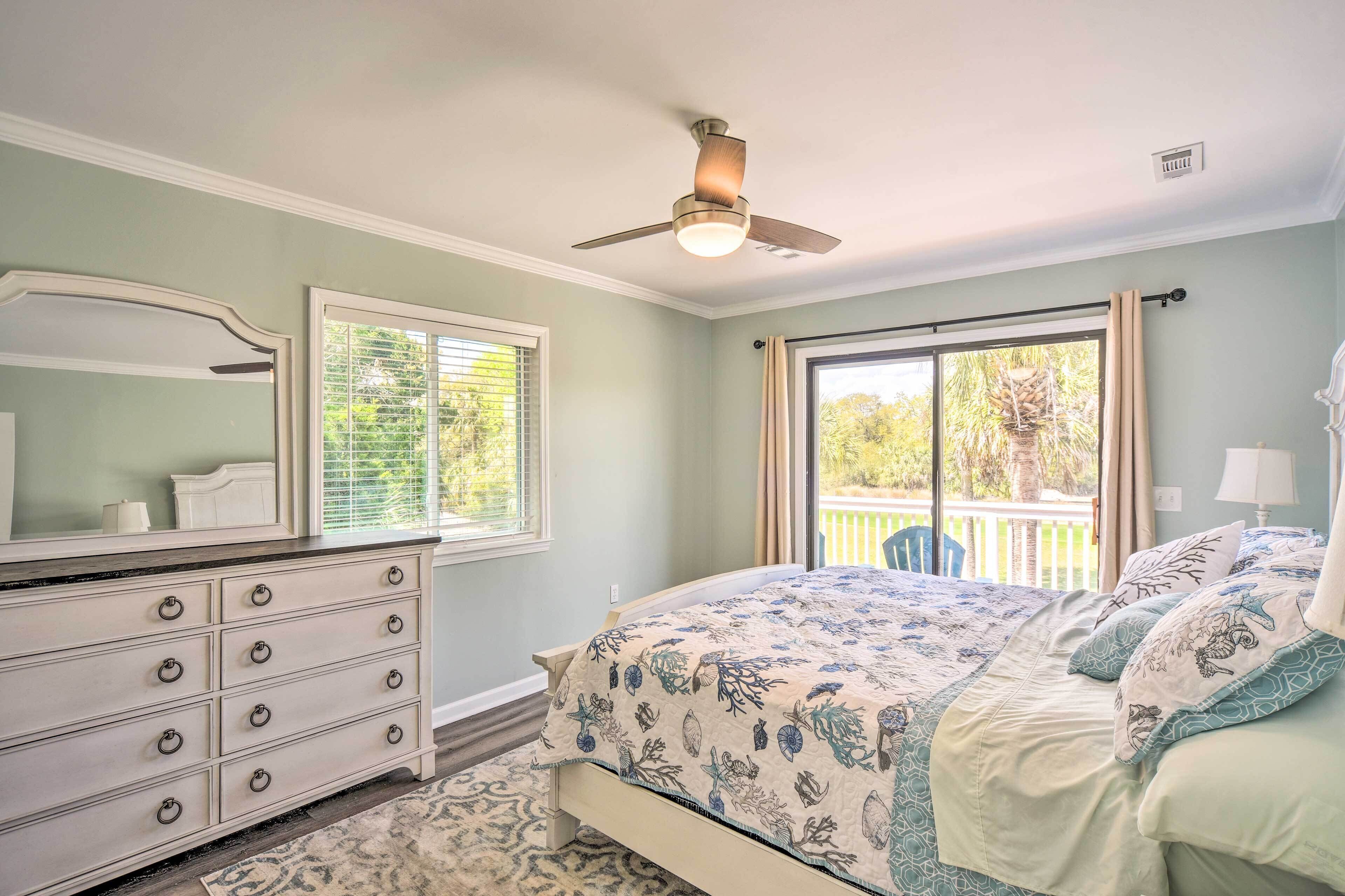 A bedroom with a bed, dresser, and a ceiling fan.