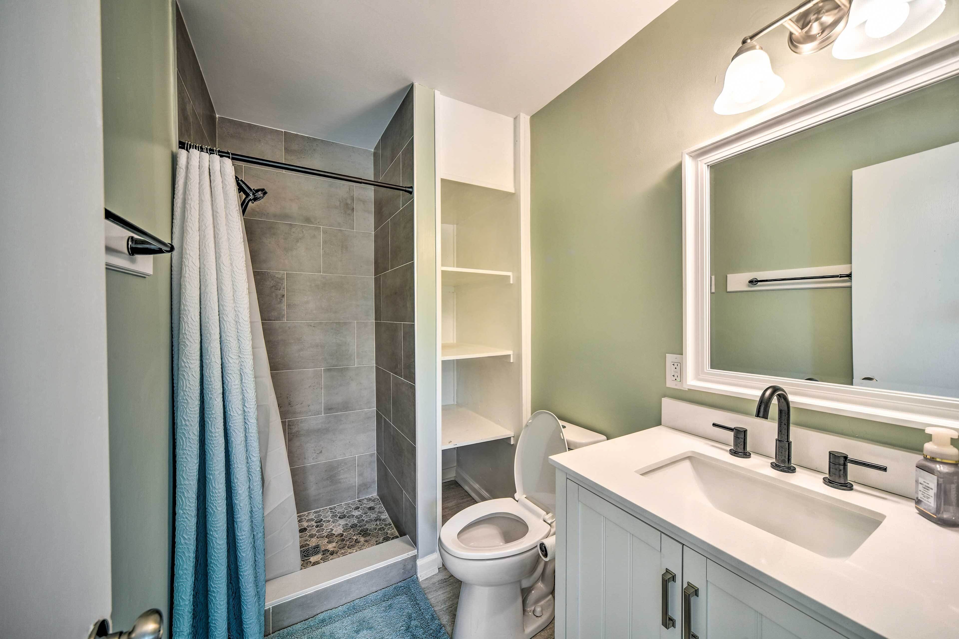 Une salle de bain avec douche, toilettes et lavabo.