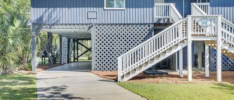 A two-story house with a covered porch and a staircase leading to the upper floor.