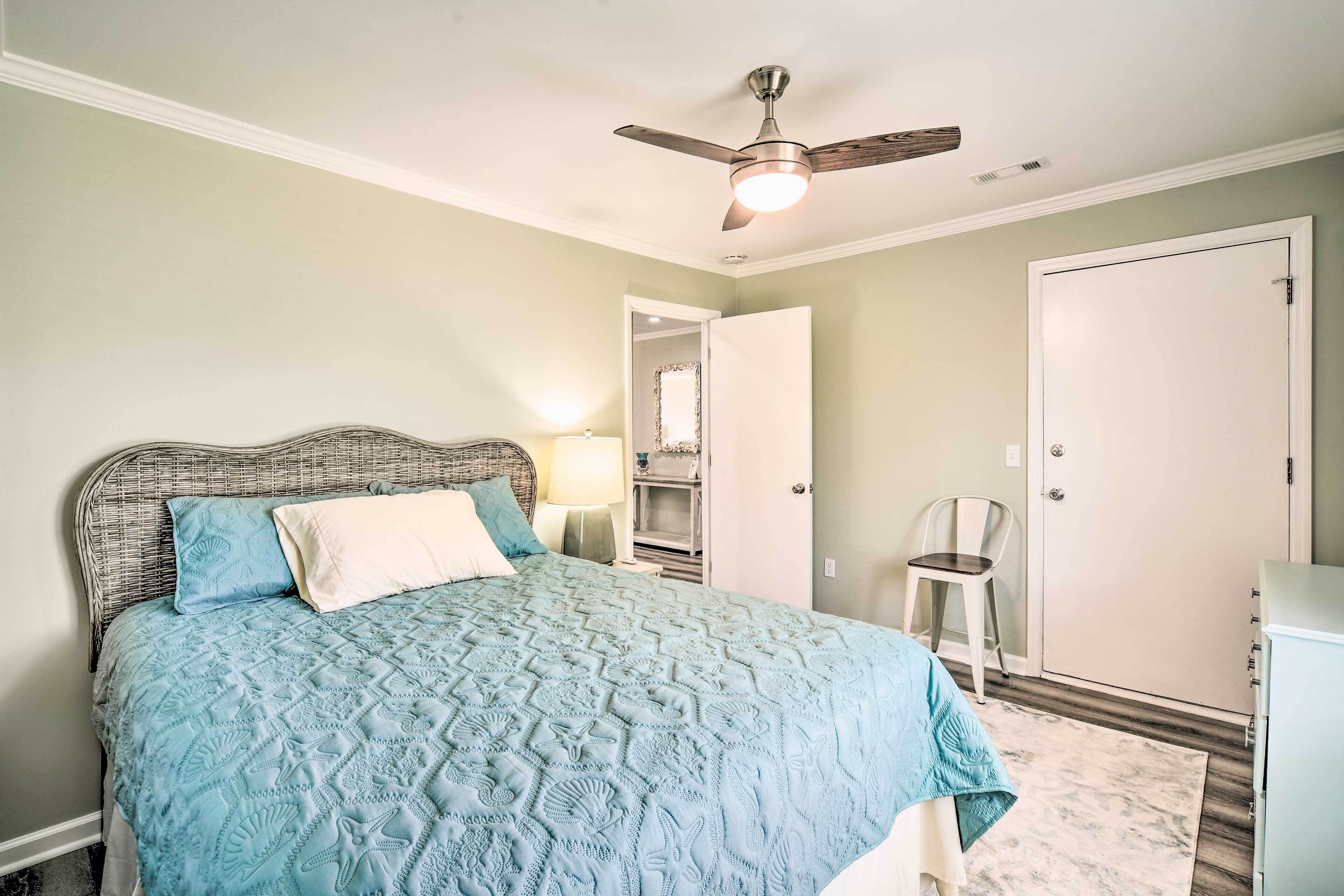 A bedroom with a bed, a ceiling fan, a wardrobe, and a chair.