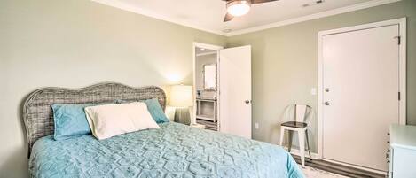 A bedroom with a bed, a ceiling fan, a wardrobe, and a chair.