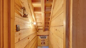 A narrow wooden hallway with a sign reading "BLUEGRASS" and a poster of a cowboy. - Cabin w/ Catch & Release Pond in Hueytown! (Bessemer)