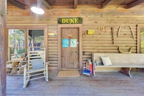 A wooden cabin with a sign reading "DUKE" above the door. There is a bench and a chair outside, a ladder, and a sign that says "Widders Rest". - Cabin w/ Catch & Release Pond in Hueytown! (Bessemer)